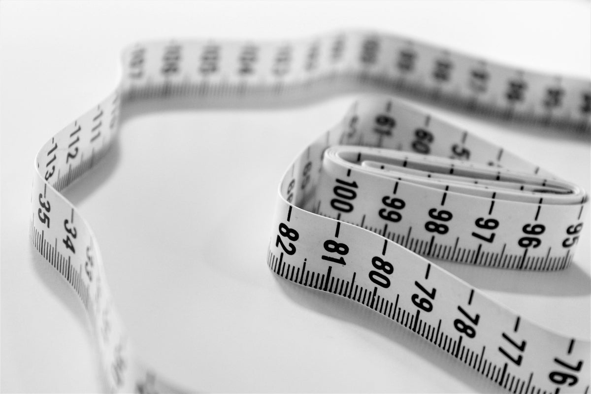 Wit meetlint met centimeters in een losse krul